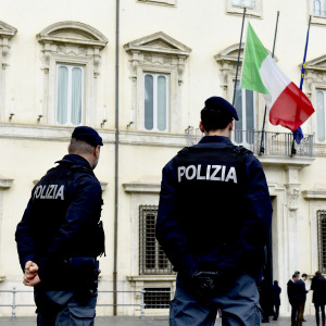 Italian police officers stand in front of the entrance to Palazzo Chigi.
