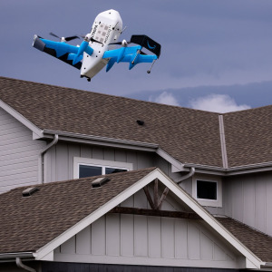 Amazon delivery drone flying above houses.