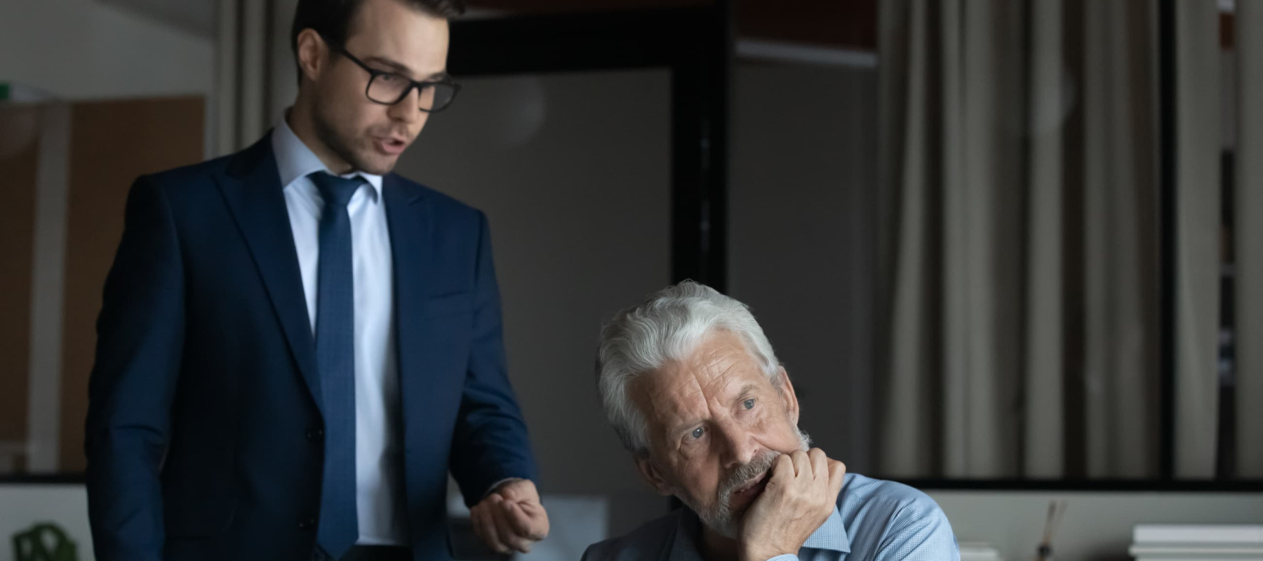 A photo of two men talking in the office