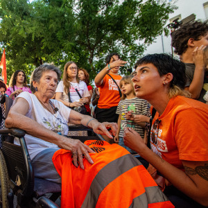 Maricarmen Abascal sits outside of her apartment with her supporters.