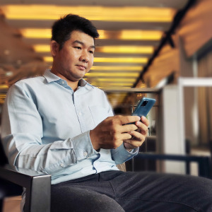A two-column photo collage of an Asian man using a mobile phone and the Northeastern University crest.