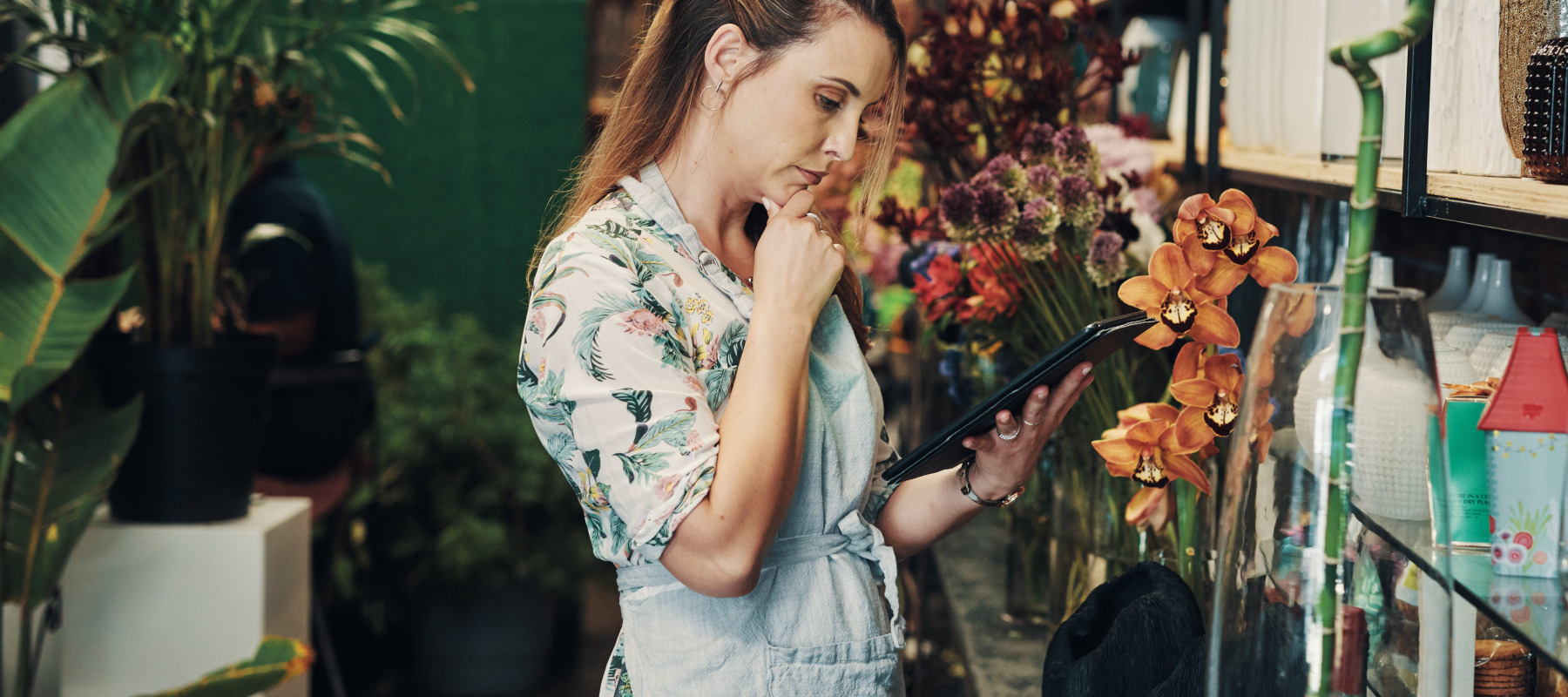 Florist observing stock and orders on a tablet