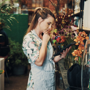 Florist observing stock and orders on a tablet