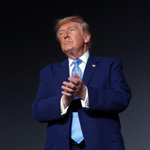 Trump applauds on stage during the America.gov launch event.