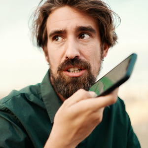 Man seen talking into his phone, looking off to the side of the camera and uncertain.