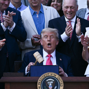 US President Donald Trump (C) holds a gavel after signing the "Big Beautiful Bill Act" at the White House in Washington, DC, and children on a school lunch line