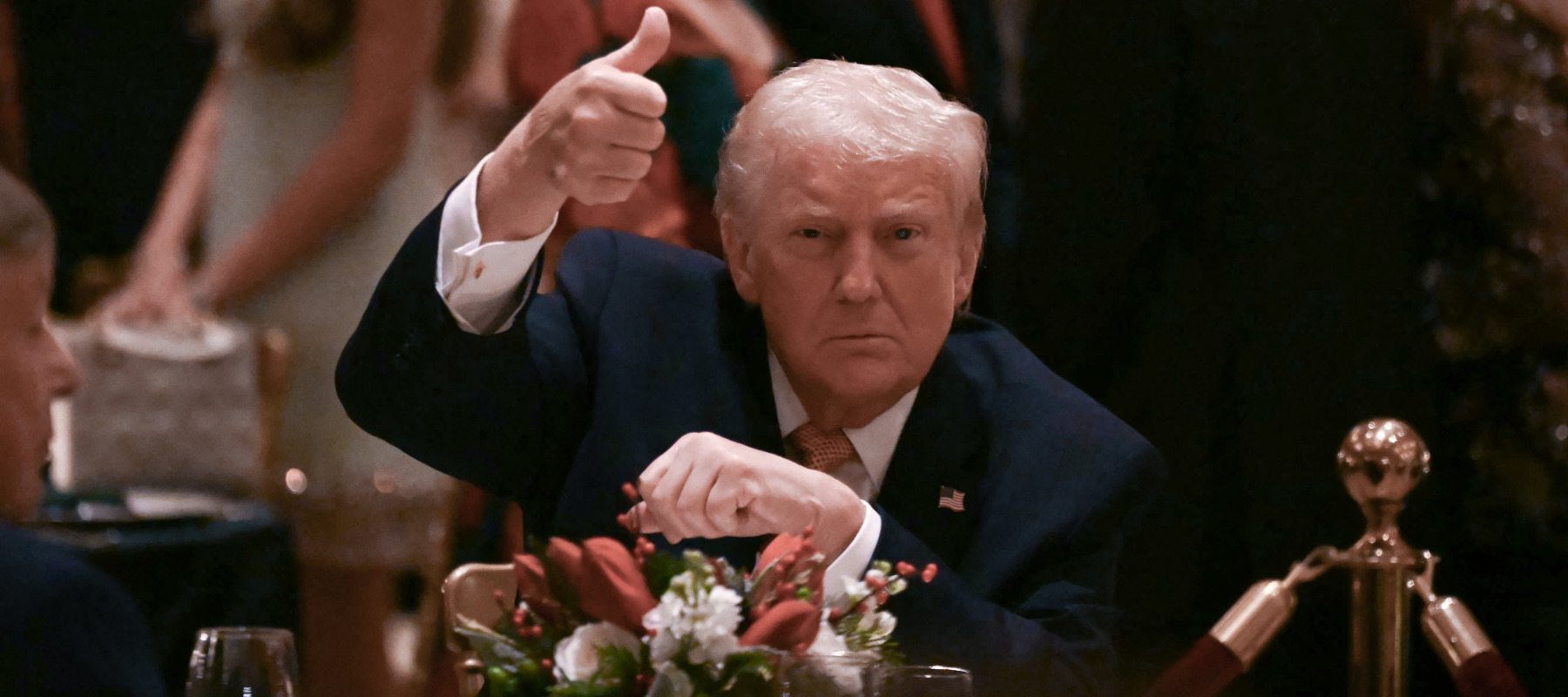 Trump gives a thumbs up as he attends a Christmas dinner at his Mar-a-Lago resort.