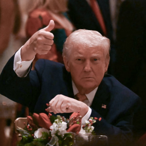 Trump gives a thumbs up as he attends a Christmas dinner at his Mar-a-Lago resort.