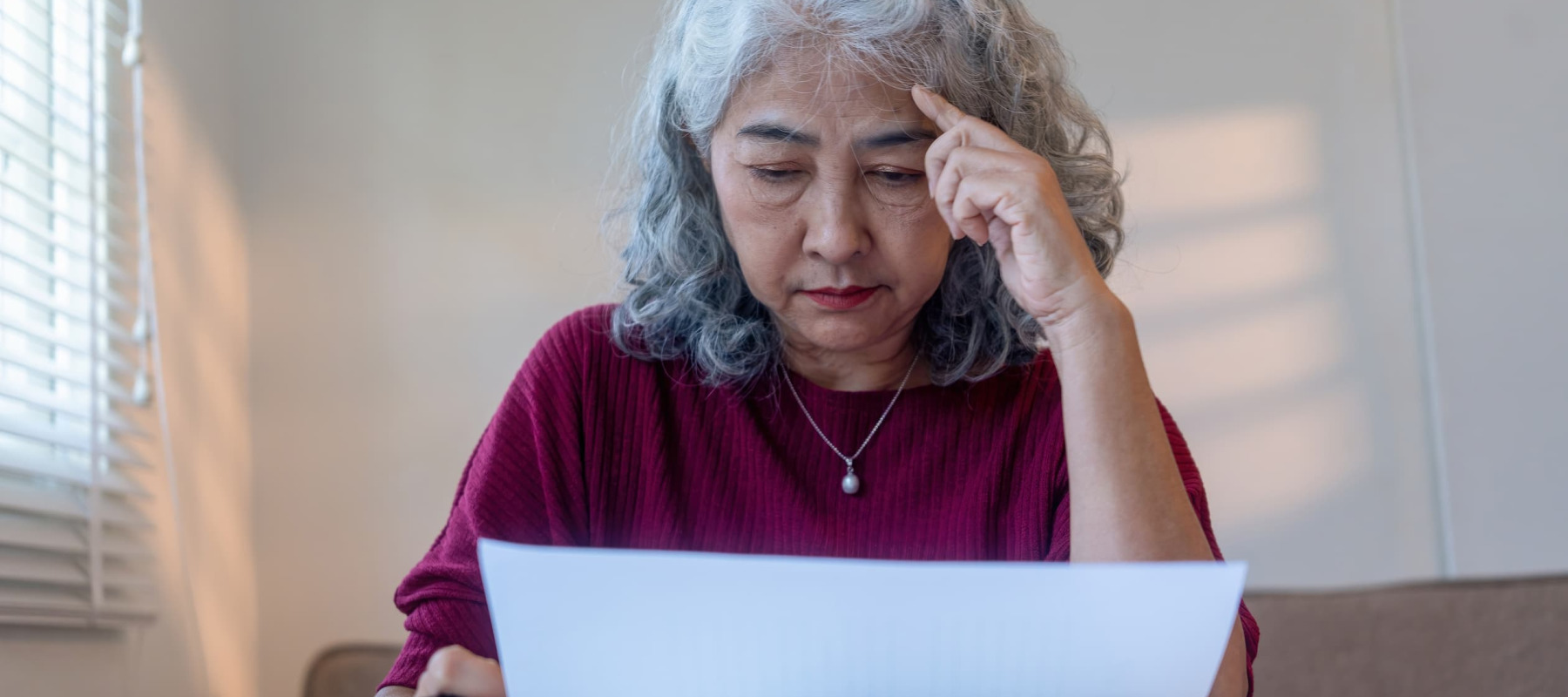 A photo of an older woman reviewing her finances
