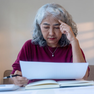 A photo of an older woman reviewing her finances