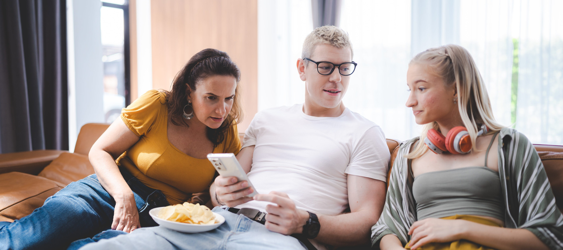 Young people sitting on couch looking at smartphone