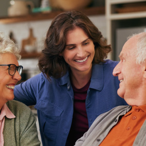 A young woman smiling between her two older parents at a breakfast table