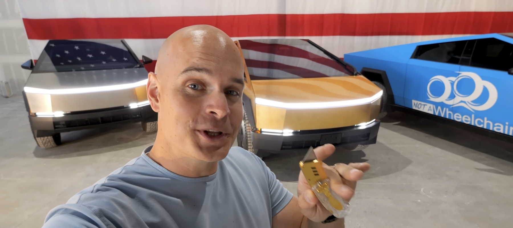 JerryRigEverything standing in front of the gold-plated Tesla Cybertruck.