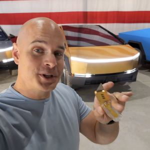 JerryRigEverything standing in front of the gold-plated Tesla Cybertruck.