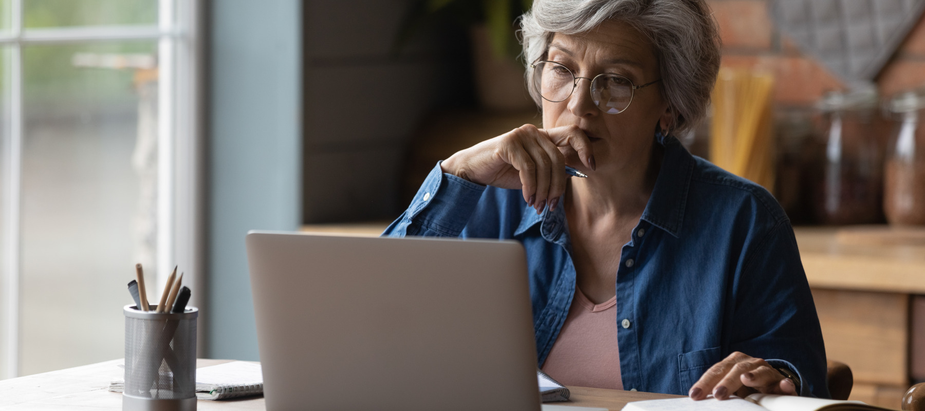 An older American woman looks at her computer.