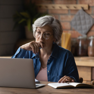 An older American woman looks at her computer.
