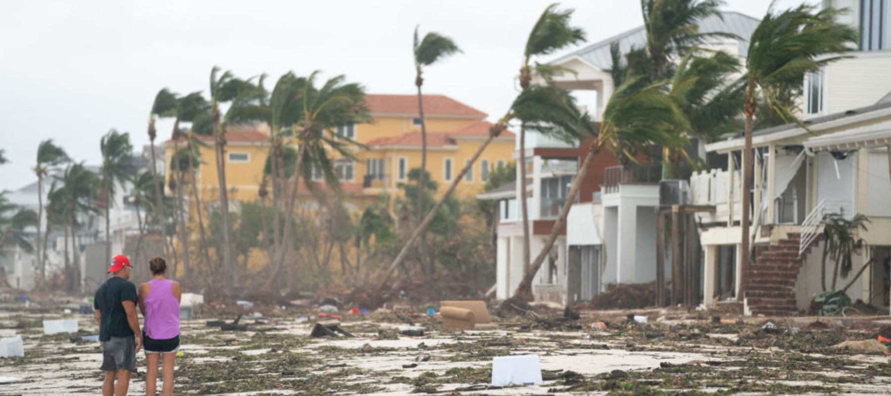 People walk along the beach looking at property damaged by Hurricane Ian on September 29, 2022 in Bonita Springs, Florida.