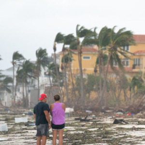 People walk along the beach looking at property damaged by Hurricane Ian on September 29, 2022 in Bonita Springs, Florida.
