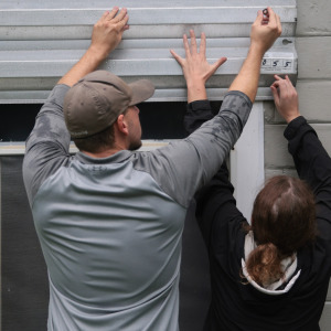Dan Conley and Suzanna Buchanan put up shutters before the arrival of Hurricane Isaias