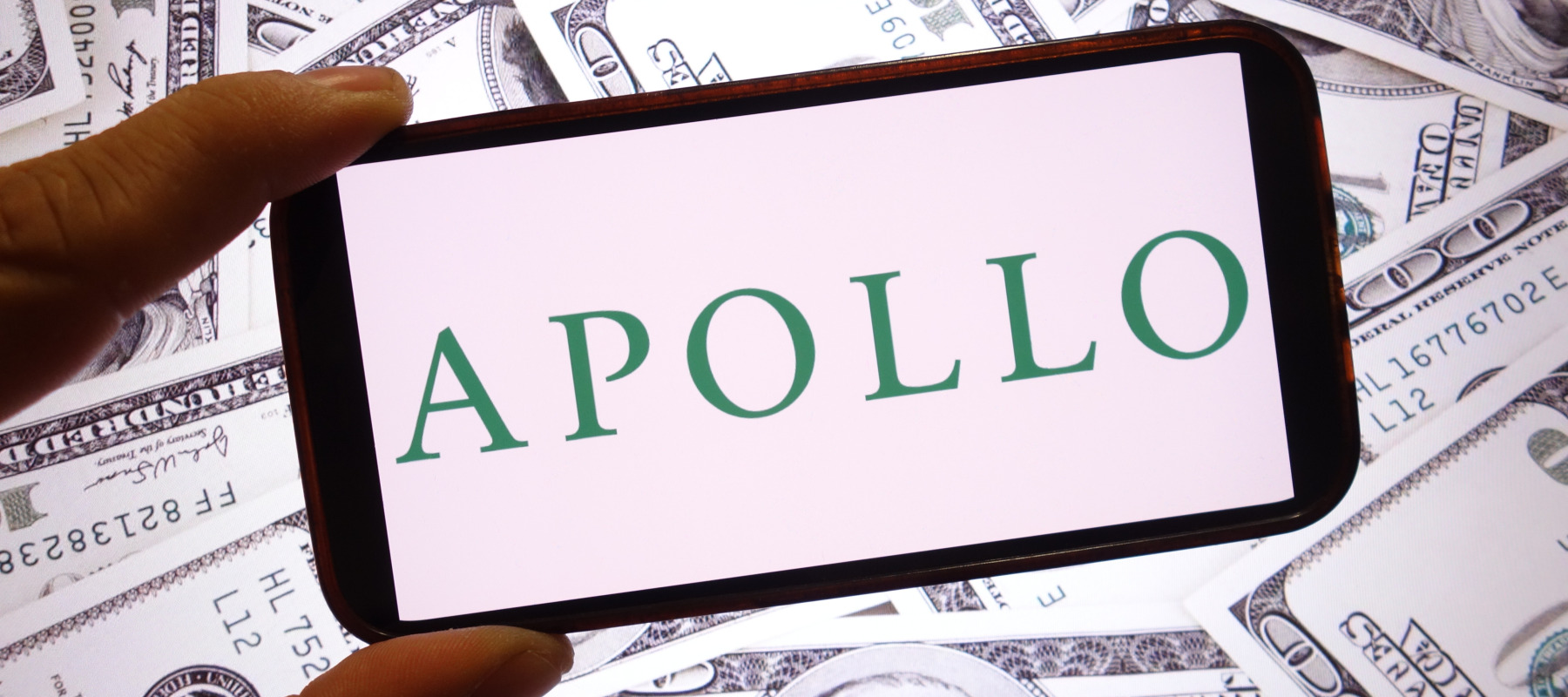 An Apollo Global Management company logo is seen displayed on a smartphone screen