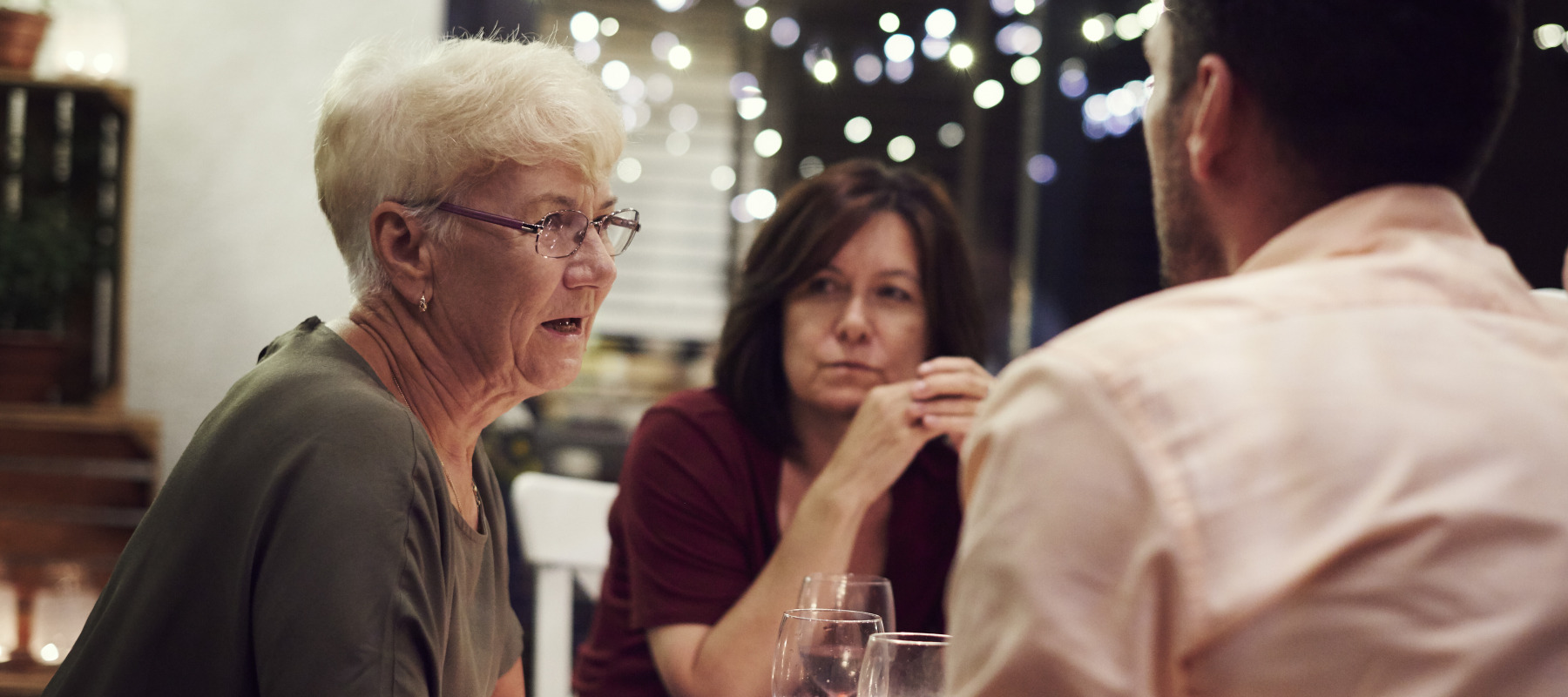 Older woman at dinner with adult children