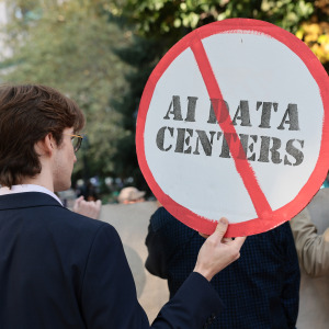 A protester holding a sing that's against AI data centers.