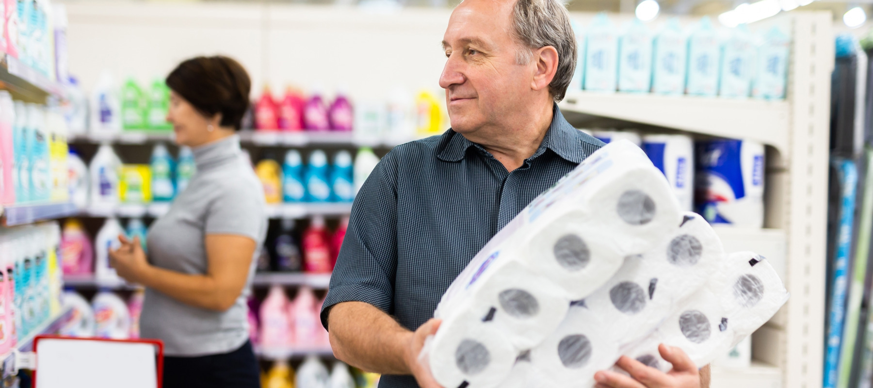 A man mulls his options while shopping for toilet paper.