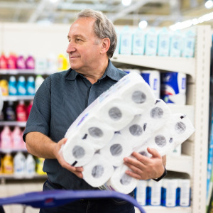 A man mulls his options while shopping for toilet paper.