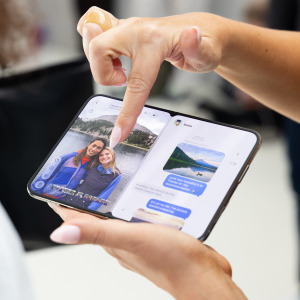 An attendee handles Apple's iPhone Duo, the company's first foldable smartphone, at Apple's "Surprise and Shine" event.