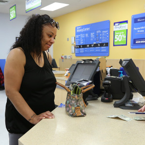 Having passed on using traditional banks, Julie Smith, of Milton, conducts business in the Walpole Walmart