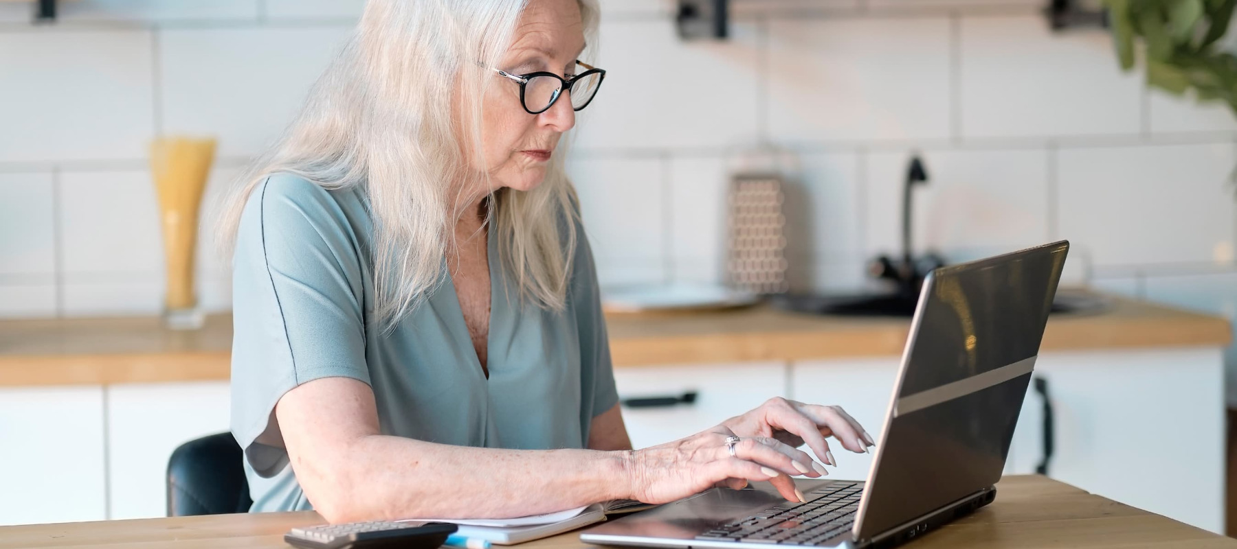 A photo of a woman reviewing her finances on a laptop