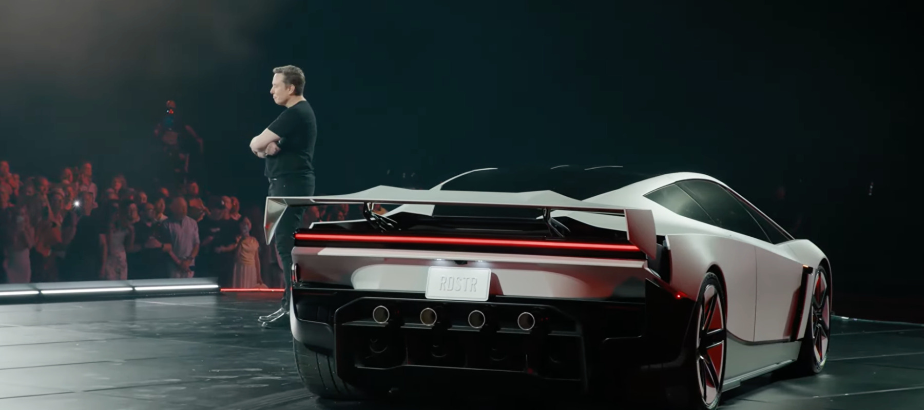 Elon Musk standing next to Tesla Roadster 2