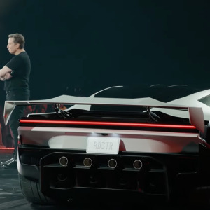 Elon Musk standing next to Tesla Roadster 2