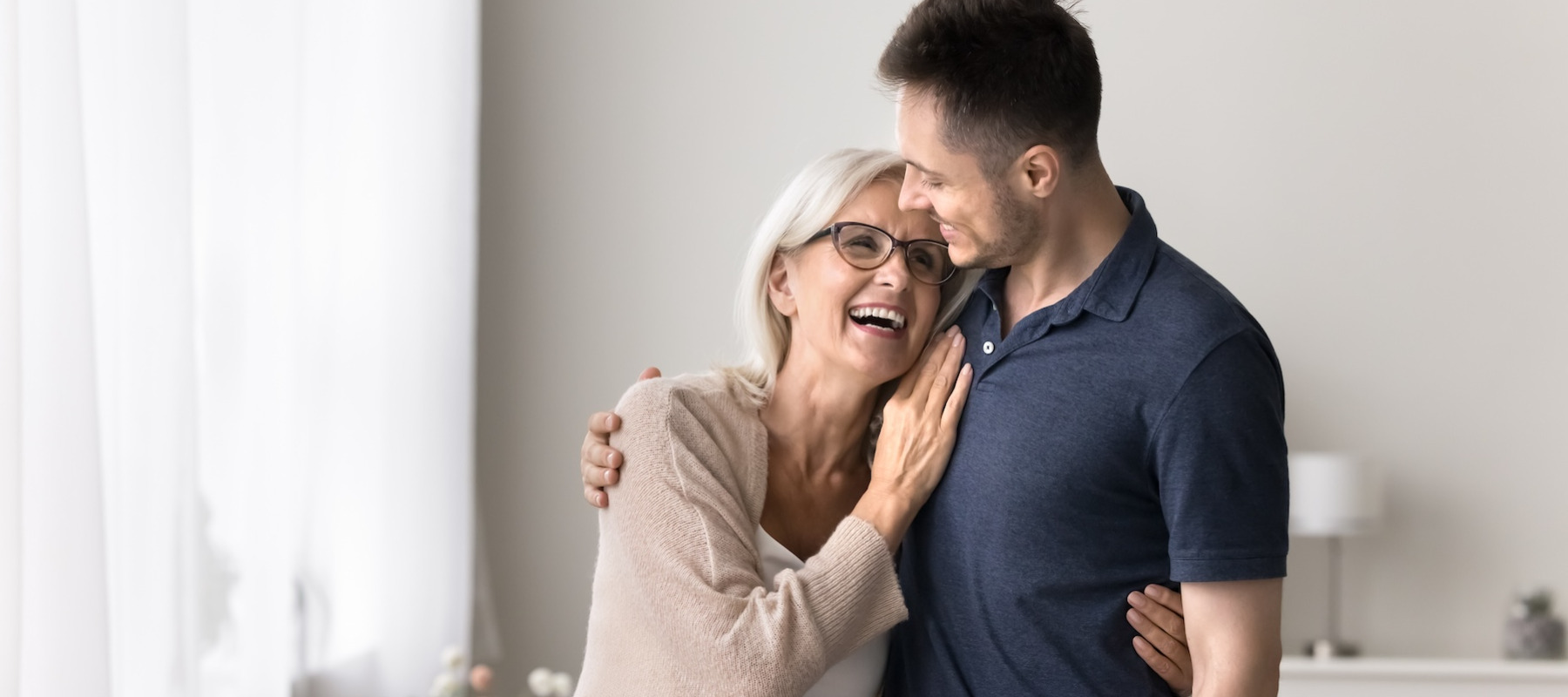 Mother and son hugging and smiling.