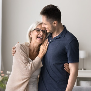 Mother and son hugging and smiling.