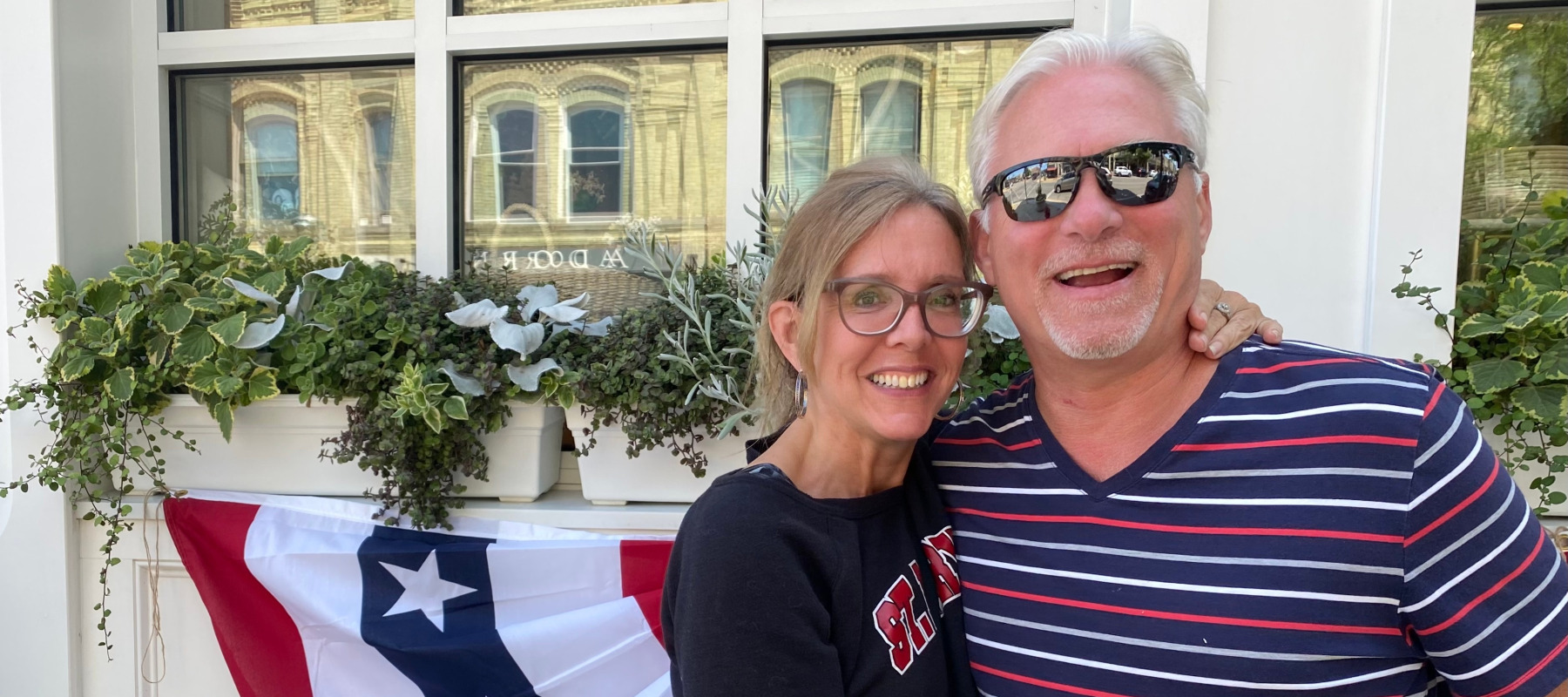 Couple pose, smiling at the camera, looking happy and at ease.