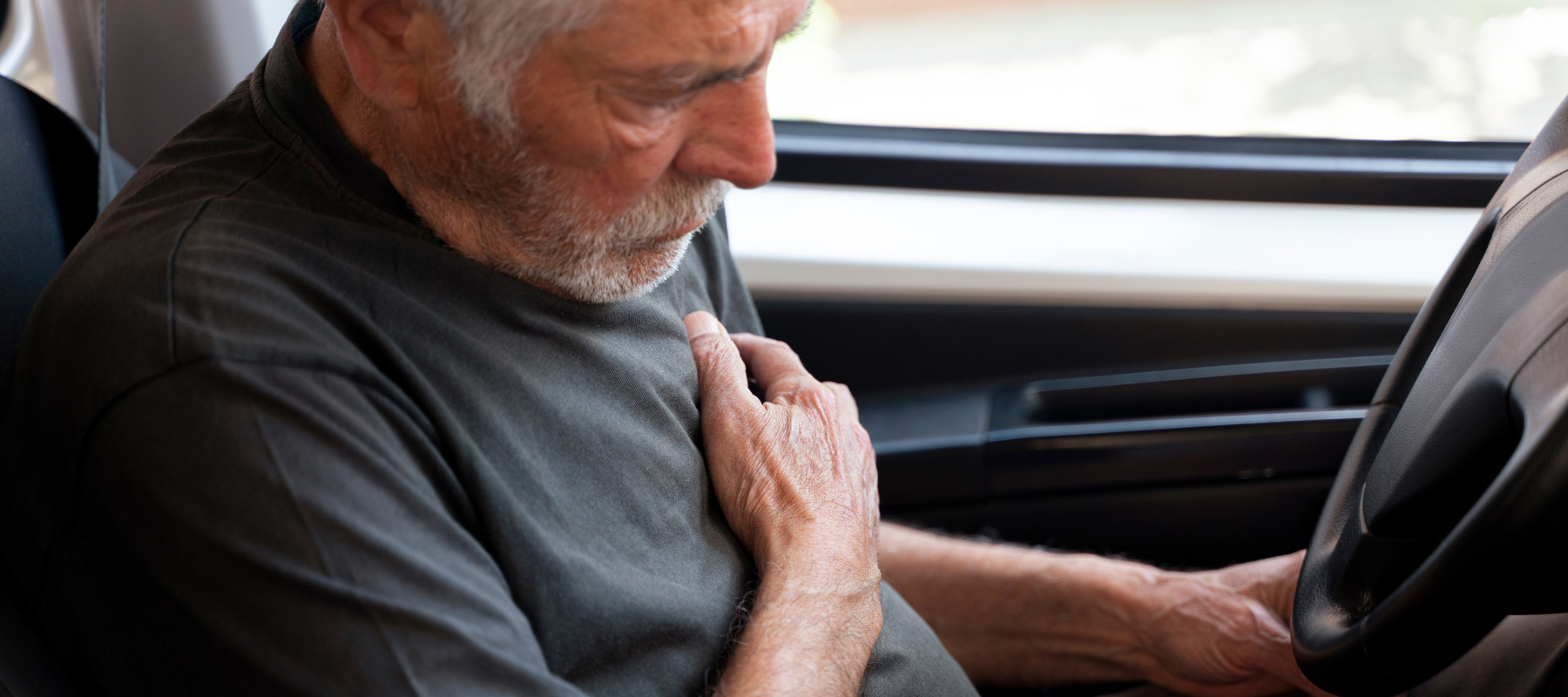 An older adult experiences a heart attack while behind the wheel of his car.