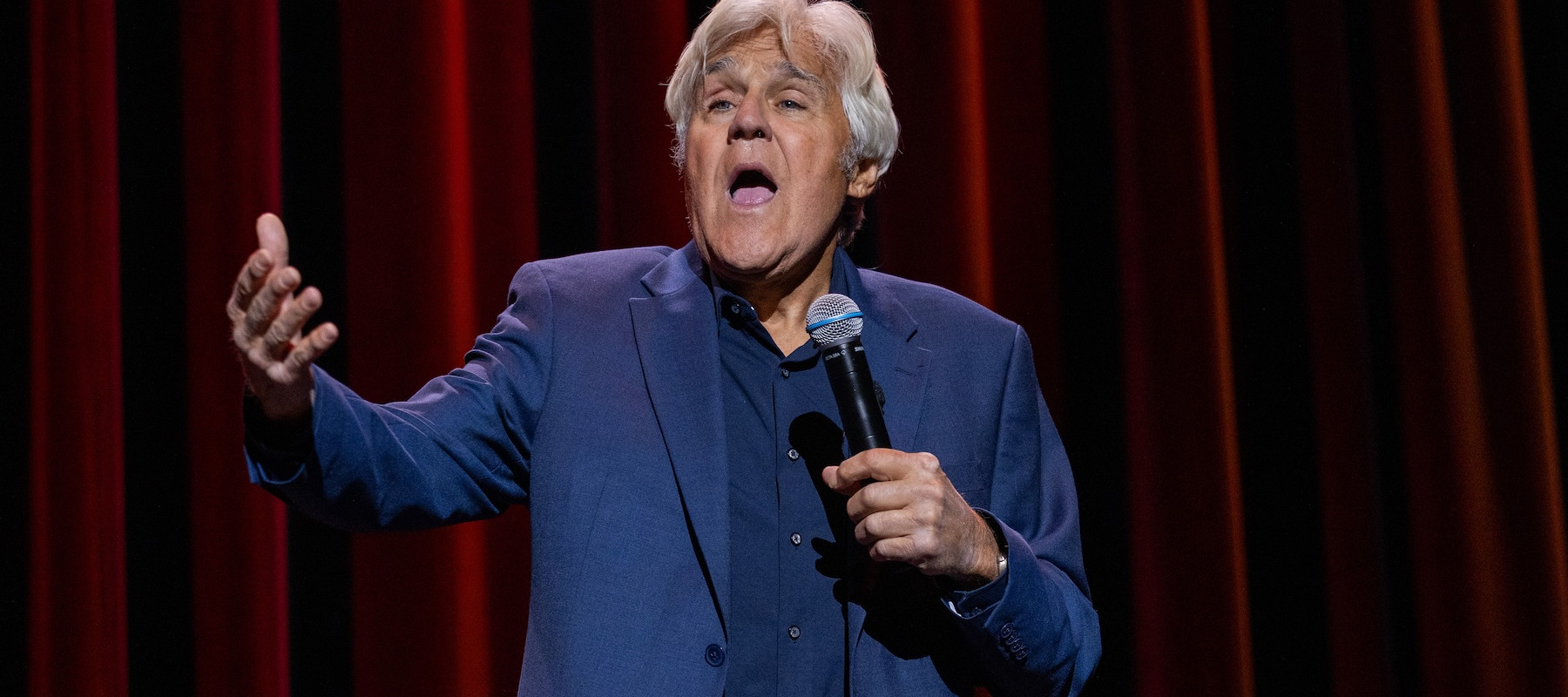 Jay Leno performing on stage.