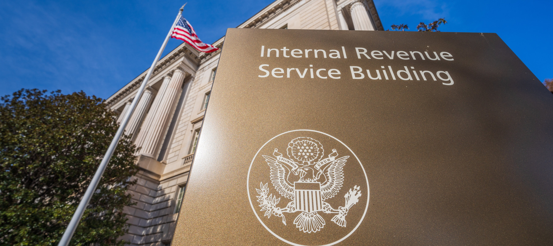 An exterior shot of the IRS offices with an American flag waving in the breeze.