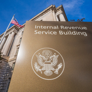An exterior shot of the IRS offices with an American flag waving in the breeze.