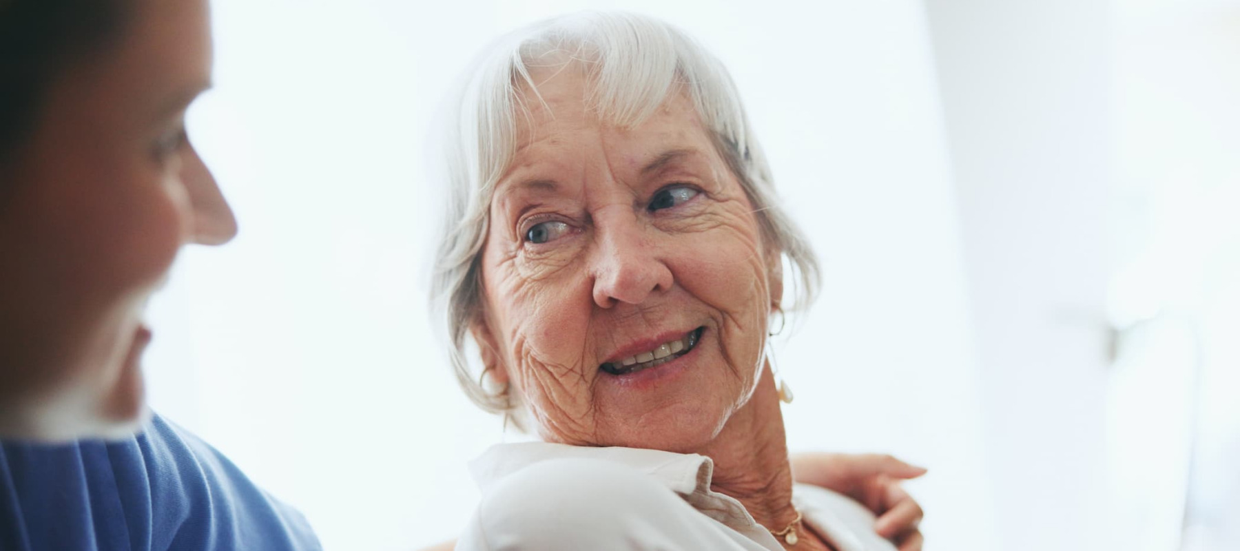 A photo of an elderly woman and a caretaker