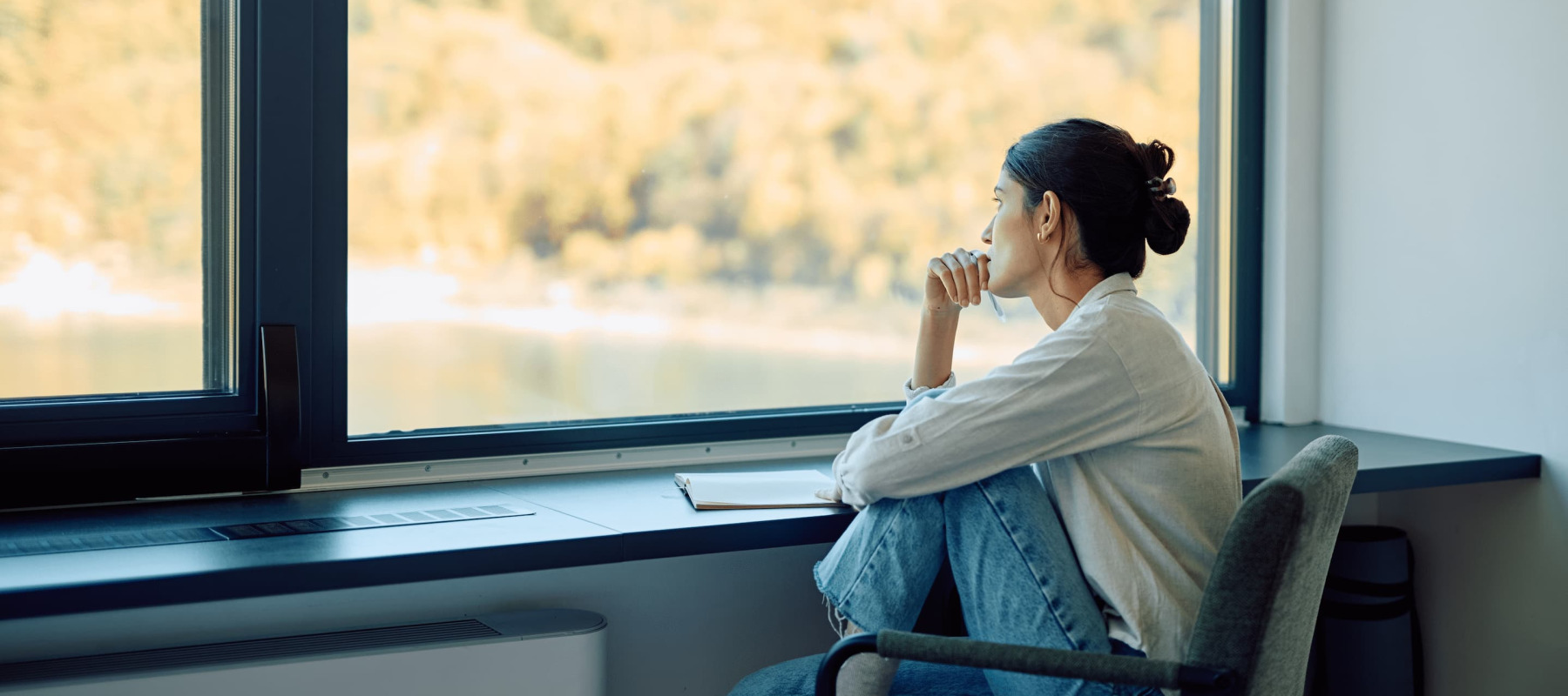 A photo of a woman thinking, looking out of the window