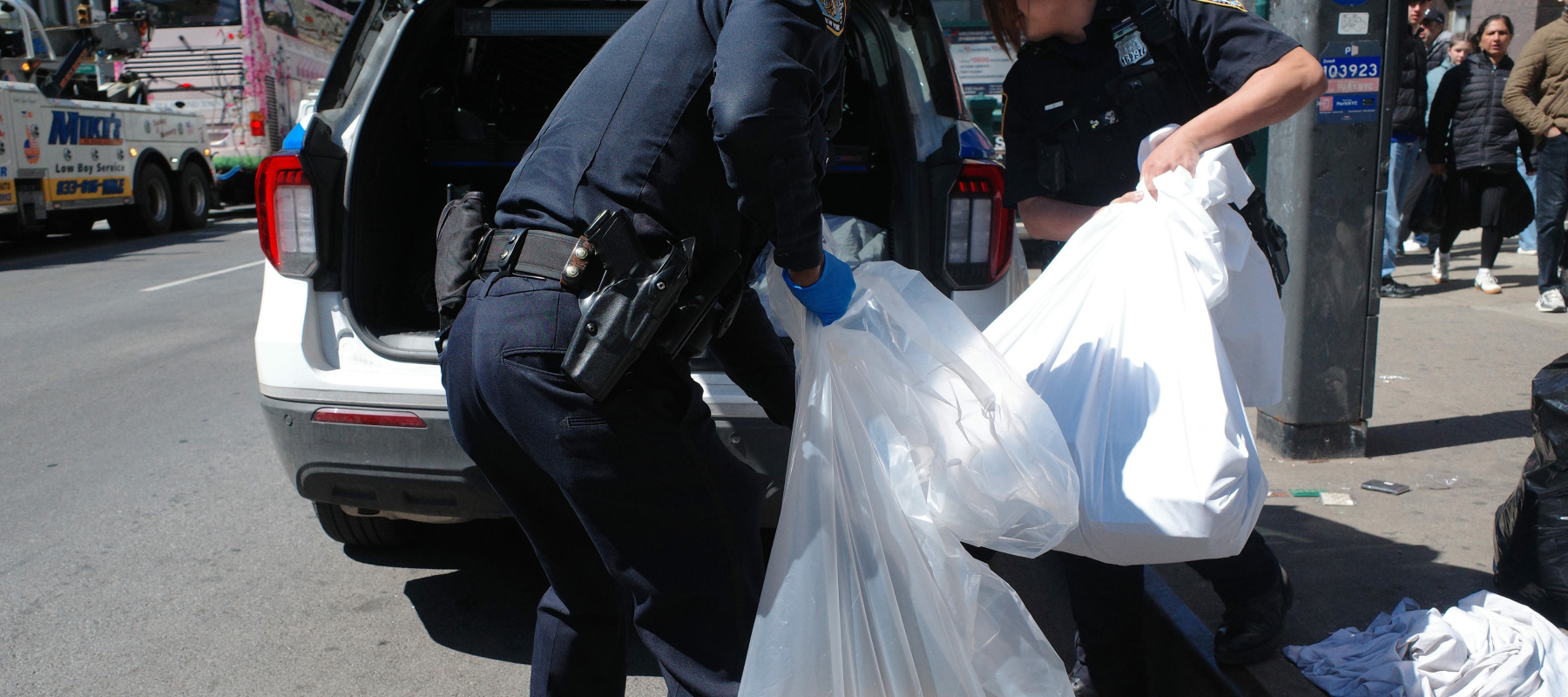 NYPD officers pack up counterfeit goods from street vendors on Canal Street on April 09, 2026