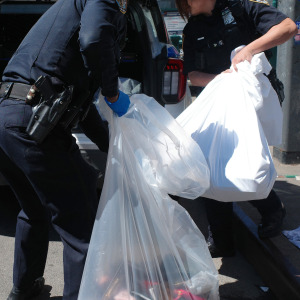 NYPD officers pack up counterfeit goods from street vendors on Canal Street on April 09, 2026