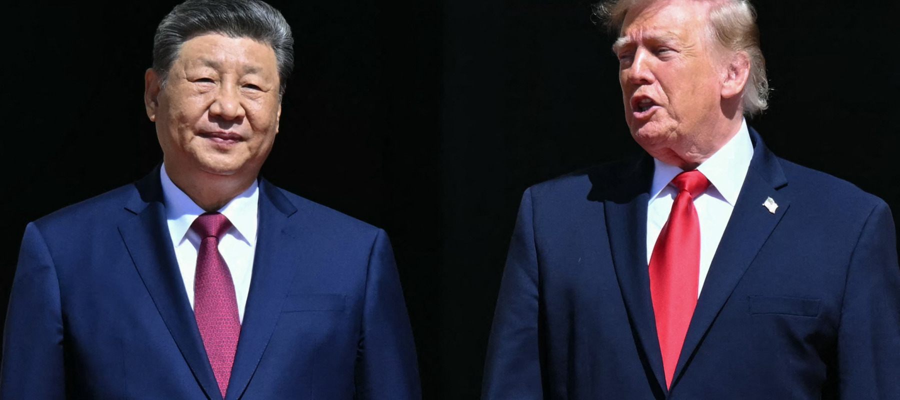 U.S. President Donald Trump stands with China's President Xi Jinping as they arrive to visit the National Archives.