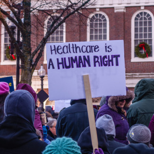 Person holding sign at protest for affordable health care