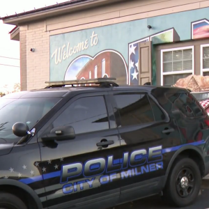 A Milner Police Department truck is parked in front of a City of Milner mural.
