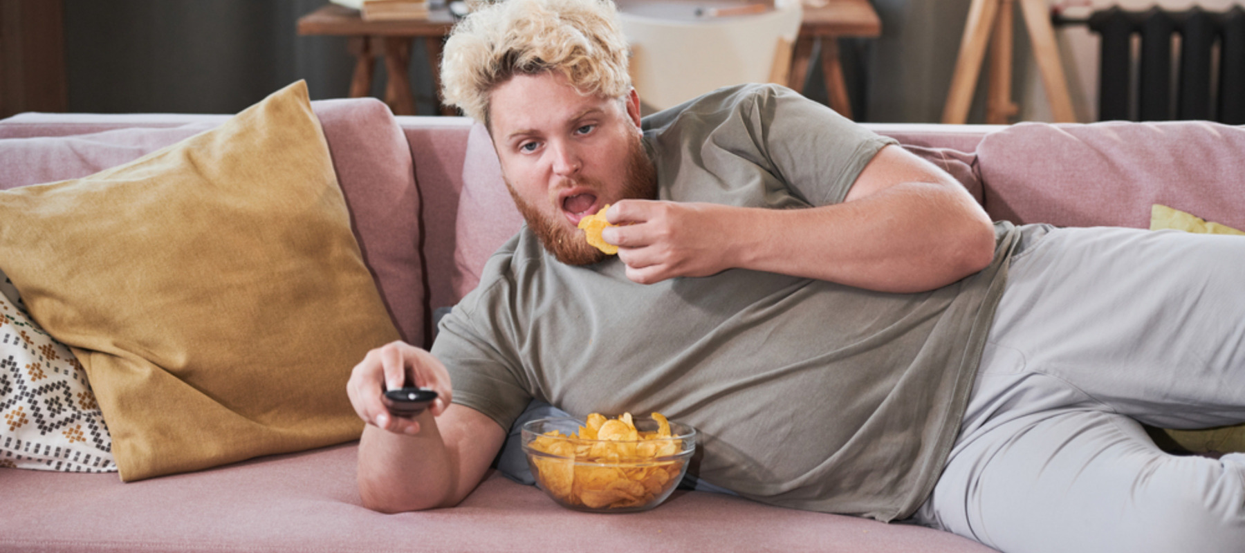 Photo of lazy man on couch eating chips