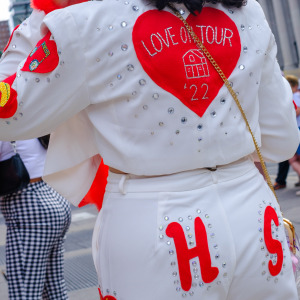 A fan wearing a Harry Styles "Love On Tour" style outfit waits to be admitted.