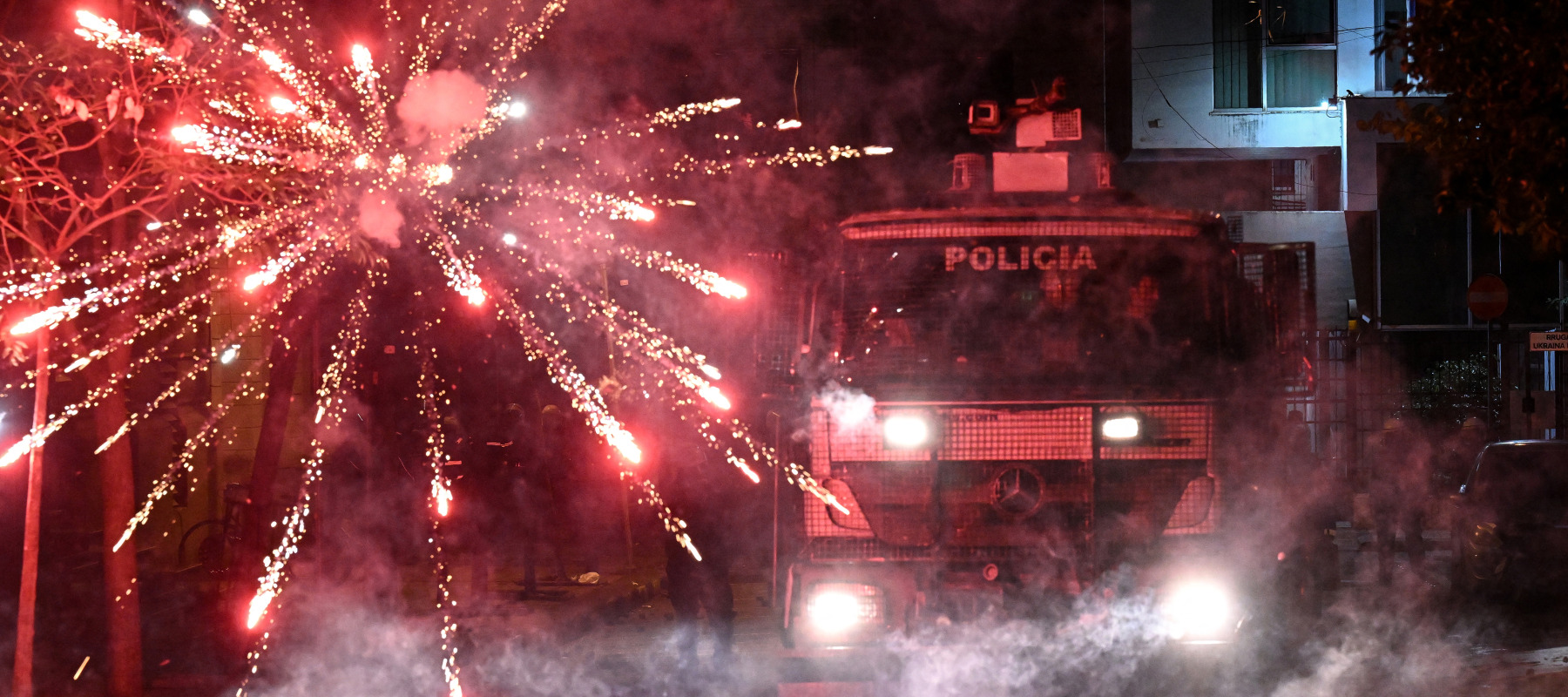 Fireworks explode next to a police truck during an anti-government demonstration.